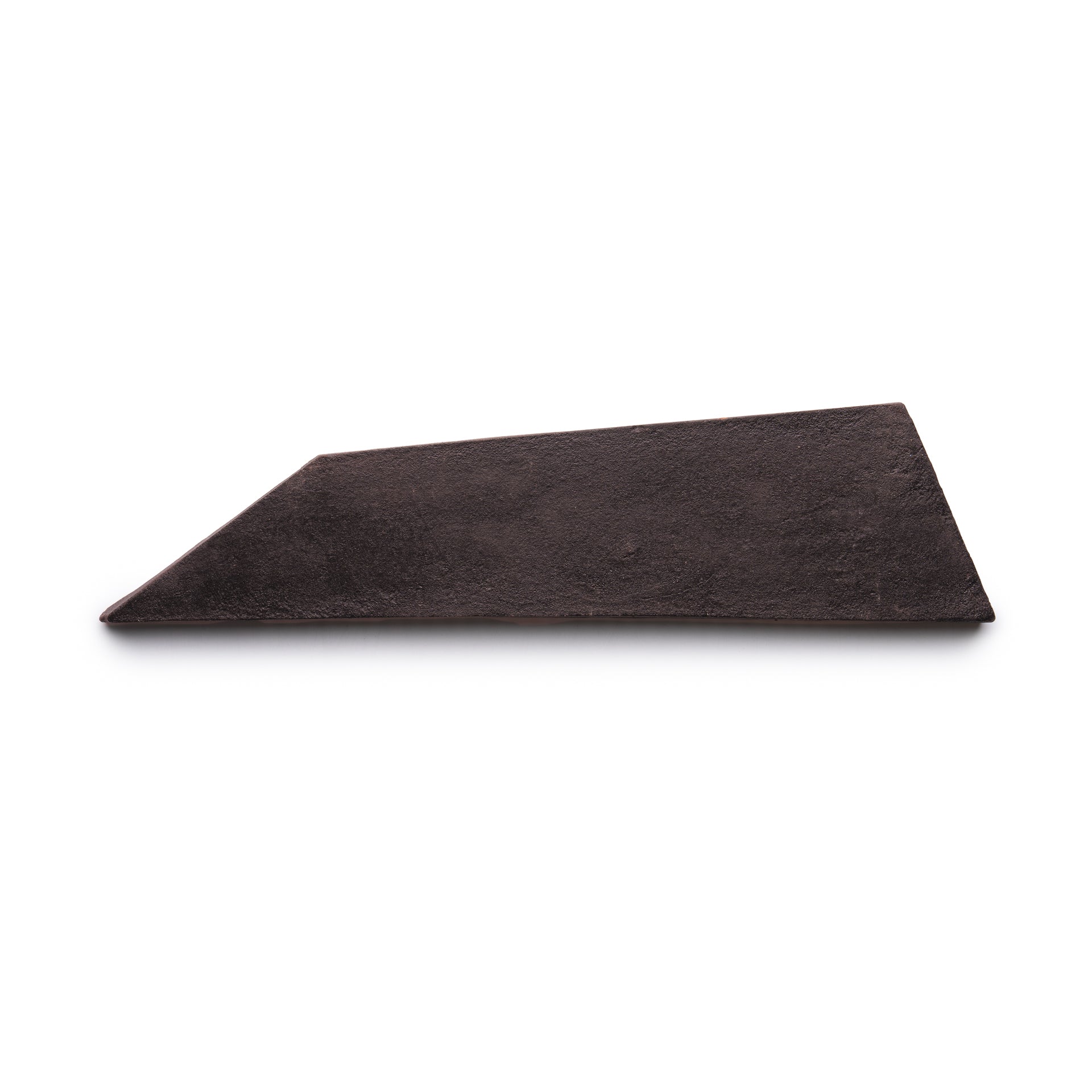 A single, irregularly shaped Tornillo + Oscura tile by Zia Tile, dark brown in color with a flat surface and angular, uneven edges, lies on a white background.