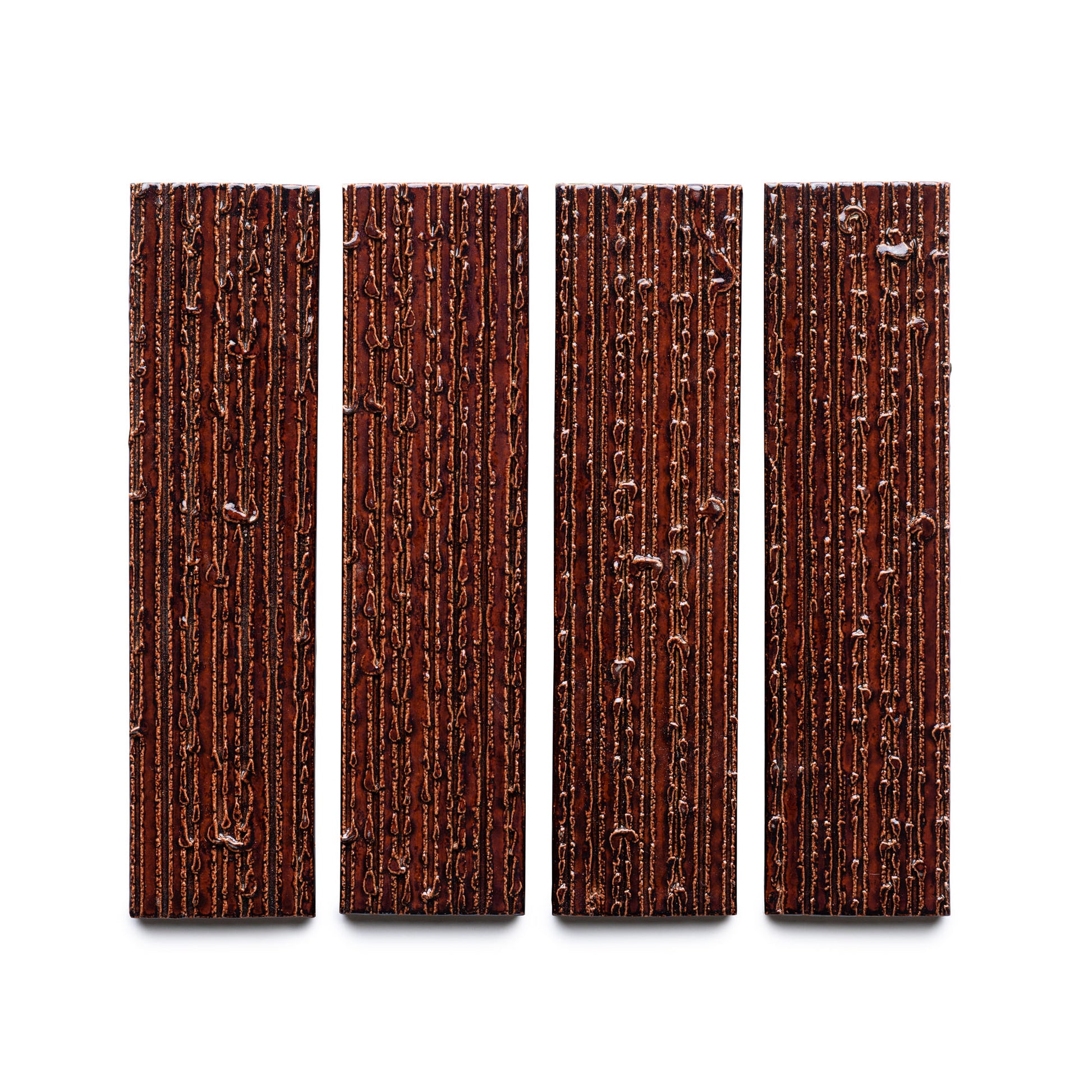 Four Oxblood + Furrowed dark chocolate bars by Zia Tile, featuring a woodgrain-like texture, are arranged vertically in a row on a white background.
