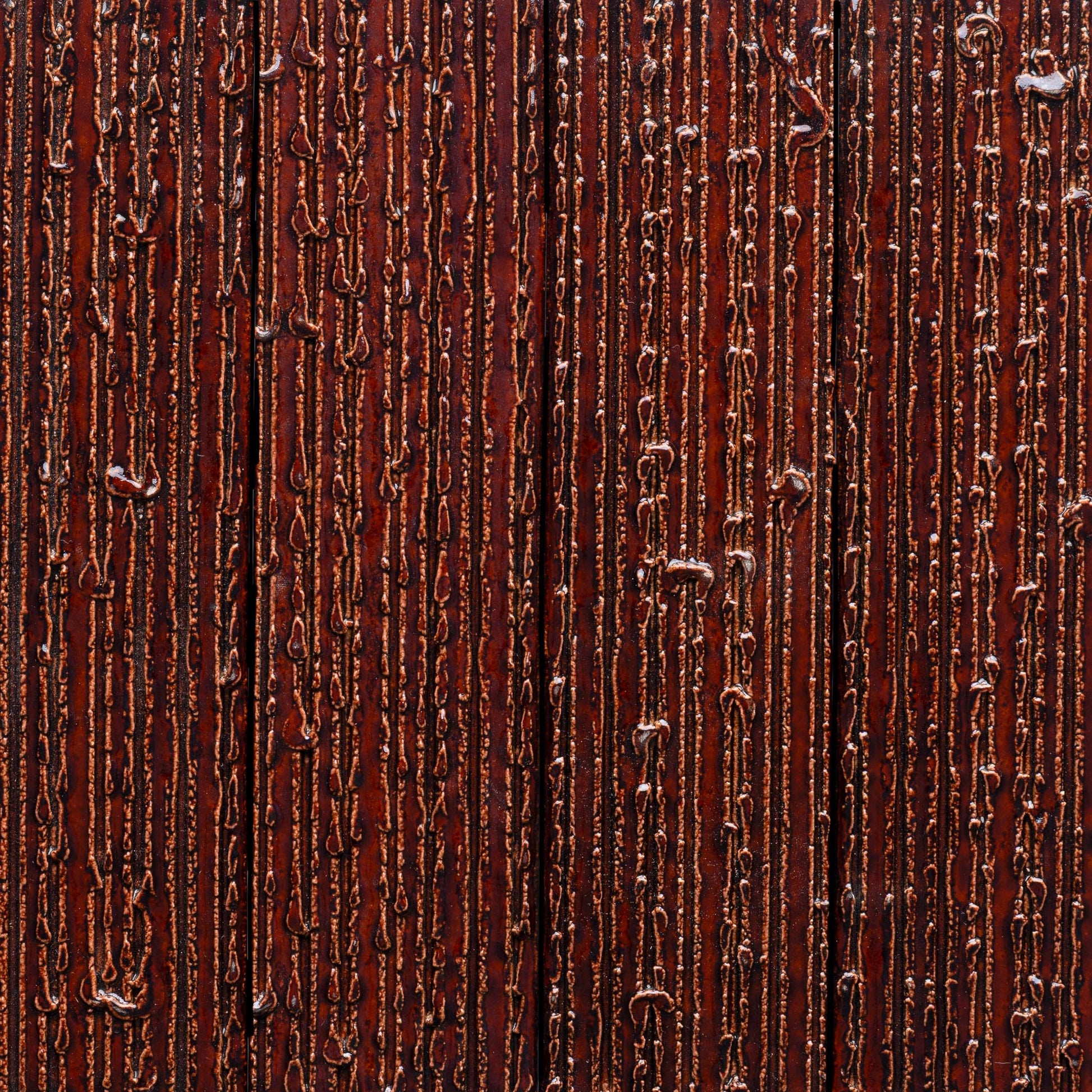 Close-up of Zia Tile’s Oxblood + Furrowed tile, featuring a textured brown surface with vertical shiny, raised ridges and lines for an abstract, tactile pattern.