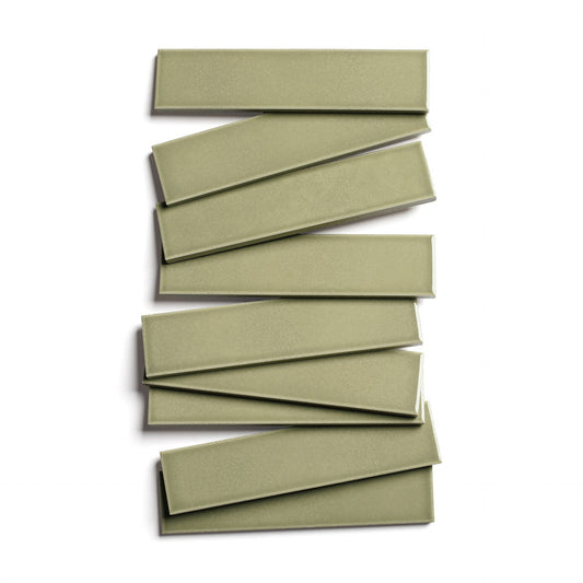 Nine Ponderosa 2x8 olive-green glossy ceramic tiles by Zia Tile are stacked in a staggered zigzag pattern on a white background.