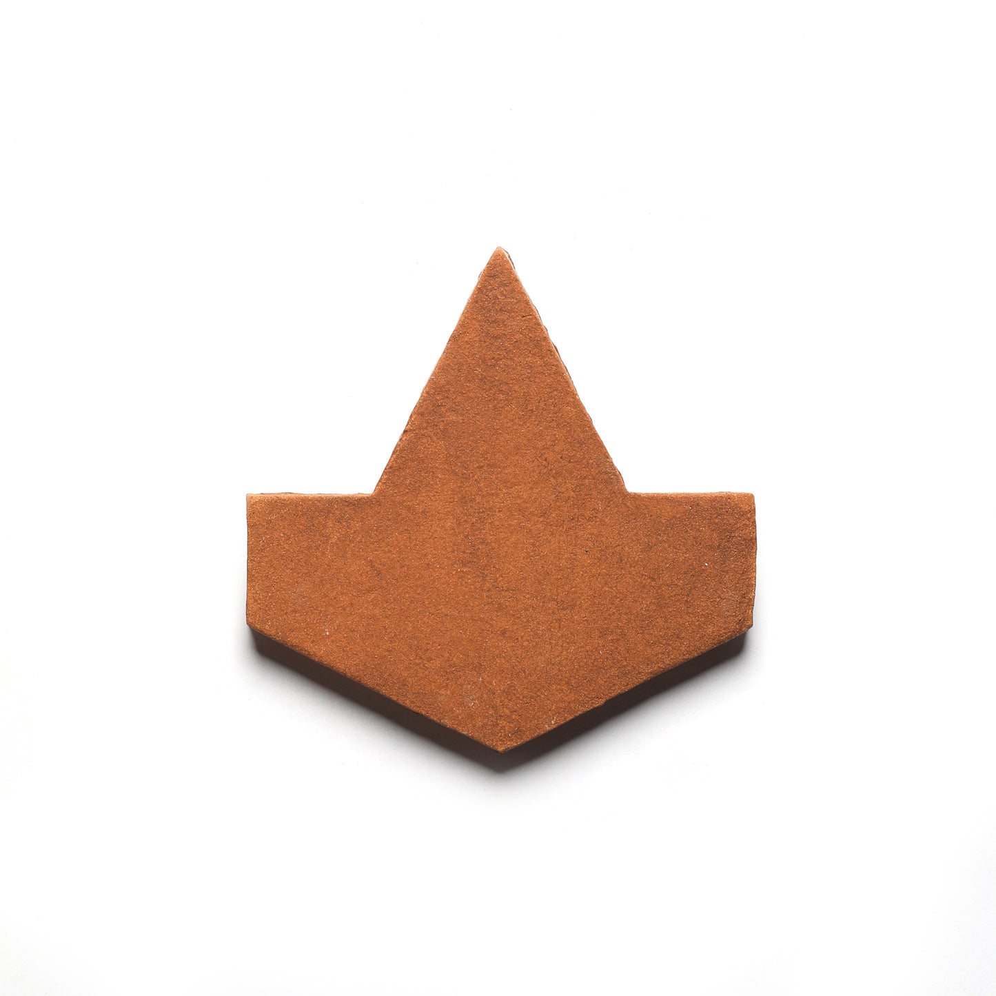The Alcazar + Red Clay tile by Zia Tile is a handmade geometric terracotta tile with an arrow-like form, pointed at the top center, shown against a plain white backdrop.