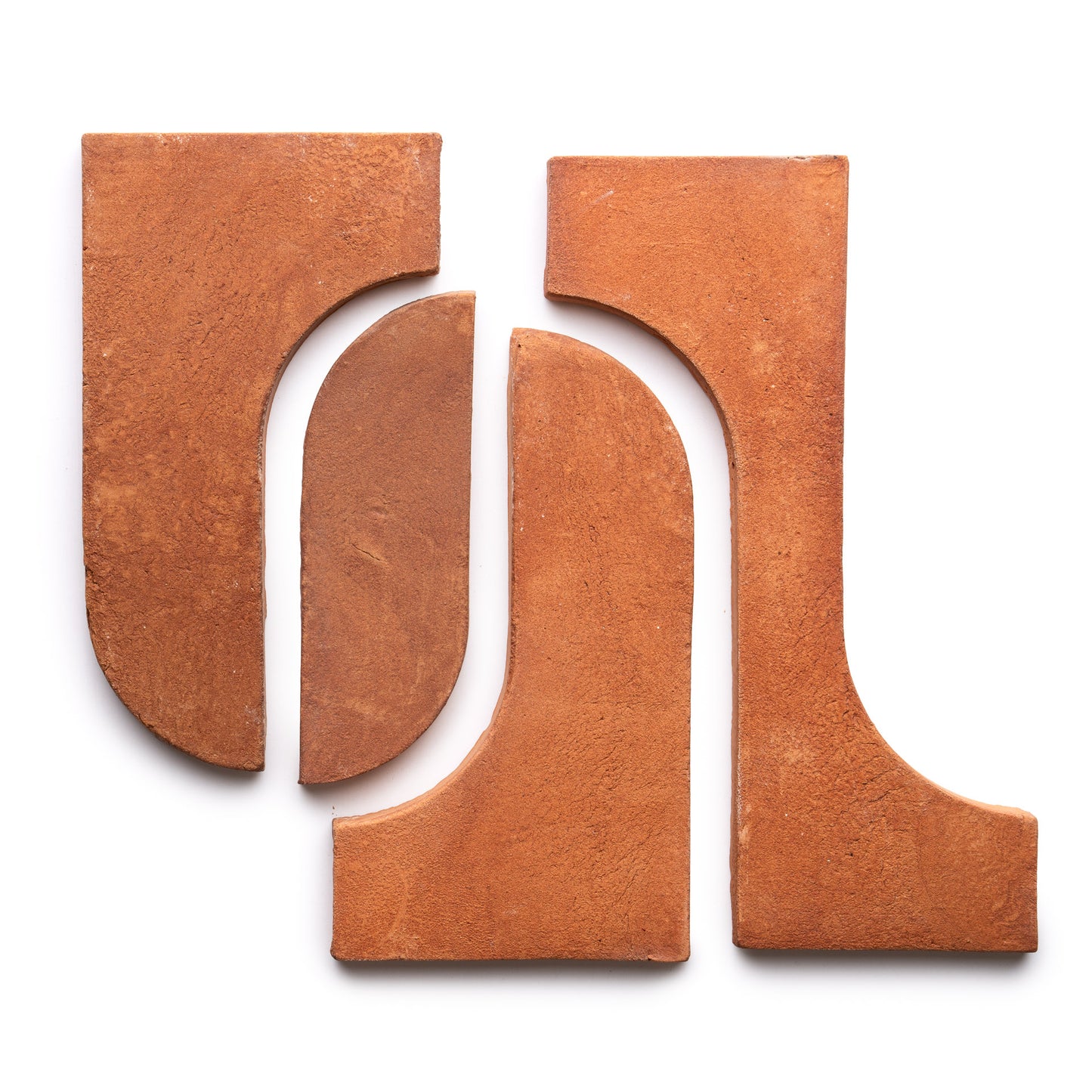 Four Durango + Red Clay terracotta tiles by Zia Tile—two with rounded inner edges and two with curved outer edges—are arranged in a symmetrical, abstract pattern on a white background.