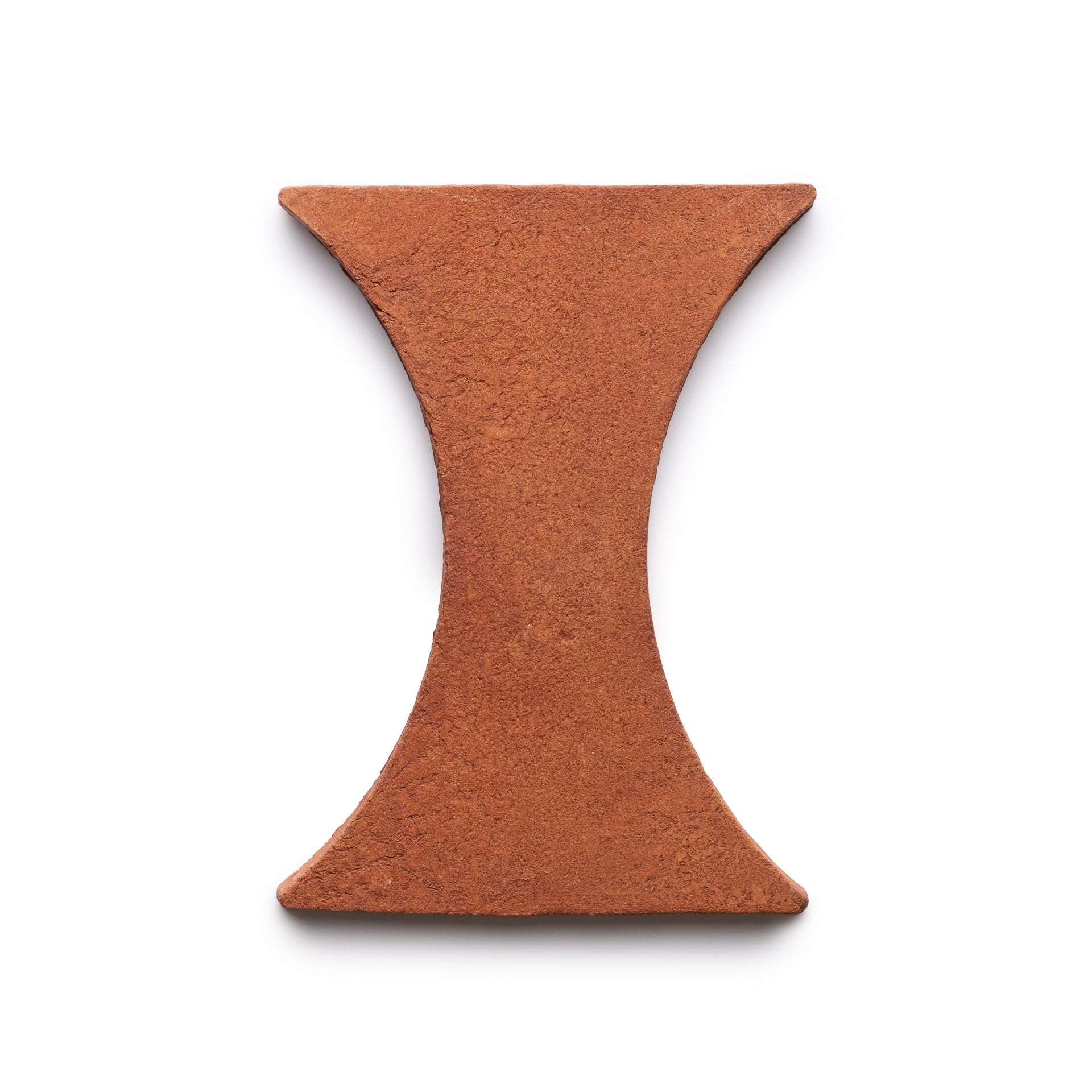A single Oaxaca + Red Clay brick by Zia Tile, featuring a reddish-brown, hourglass shape and rough texture, displayed on a white background.