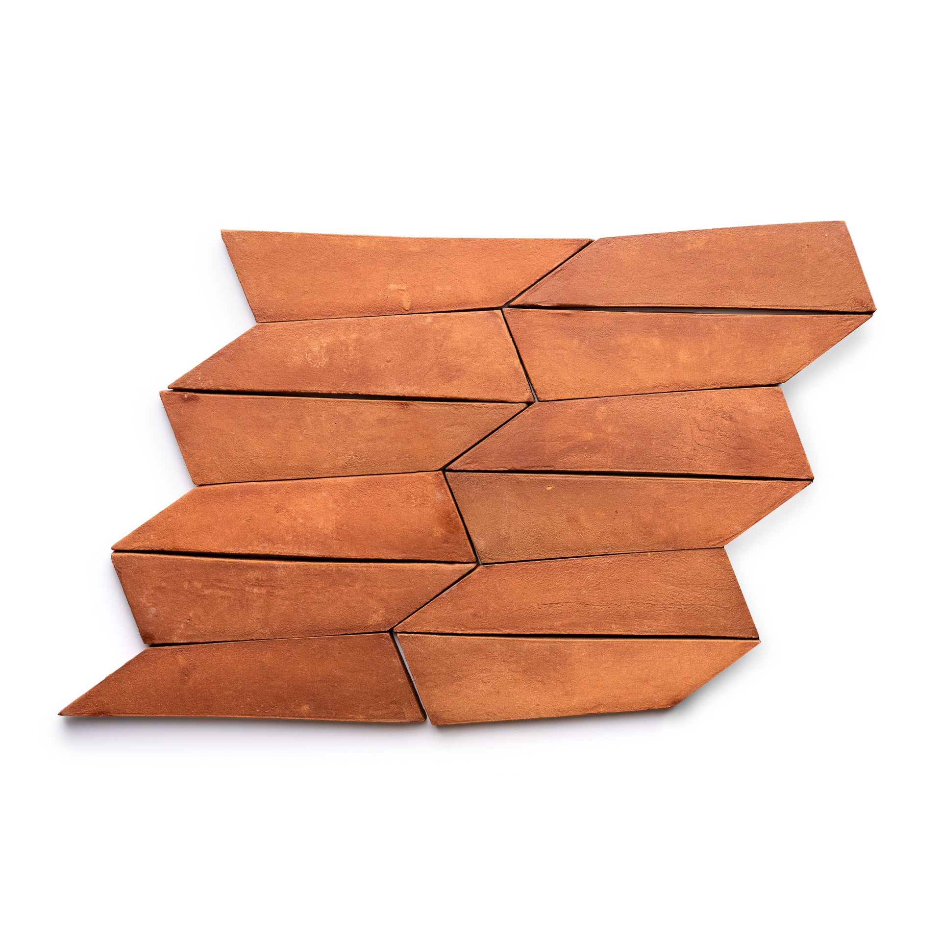 Eight Tornillo + Red Clay parallelogram tiles by Zia Tile are arranged in a staggered, interlocking pattern on a white background, creating a striking zigzag effect with their terracotta hue.
