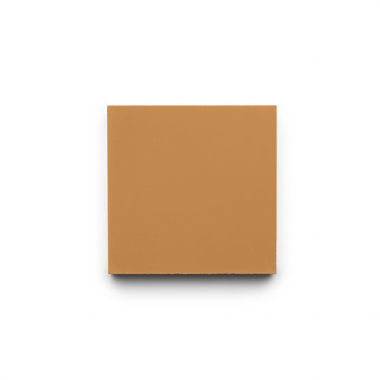 The Saddle 4x4 tile by Zia Tile is a single, plain, square cement tile in a solid light brown color, centered on a white background with a faint shadow underneath.