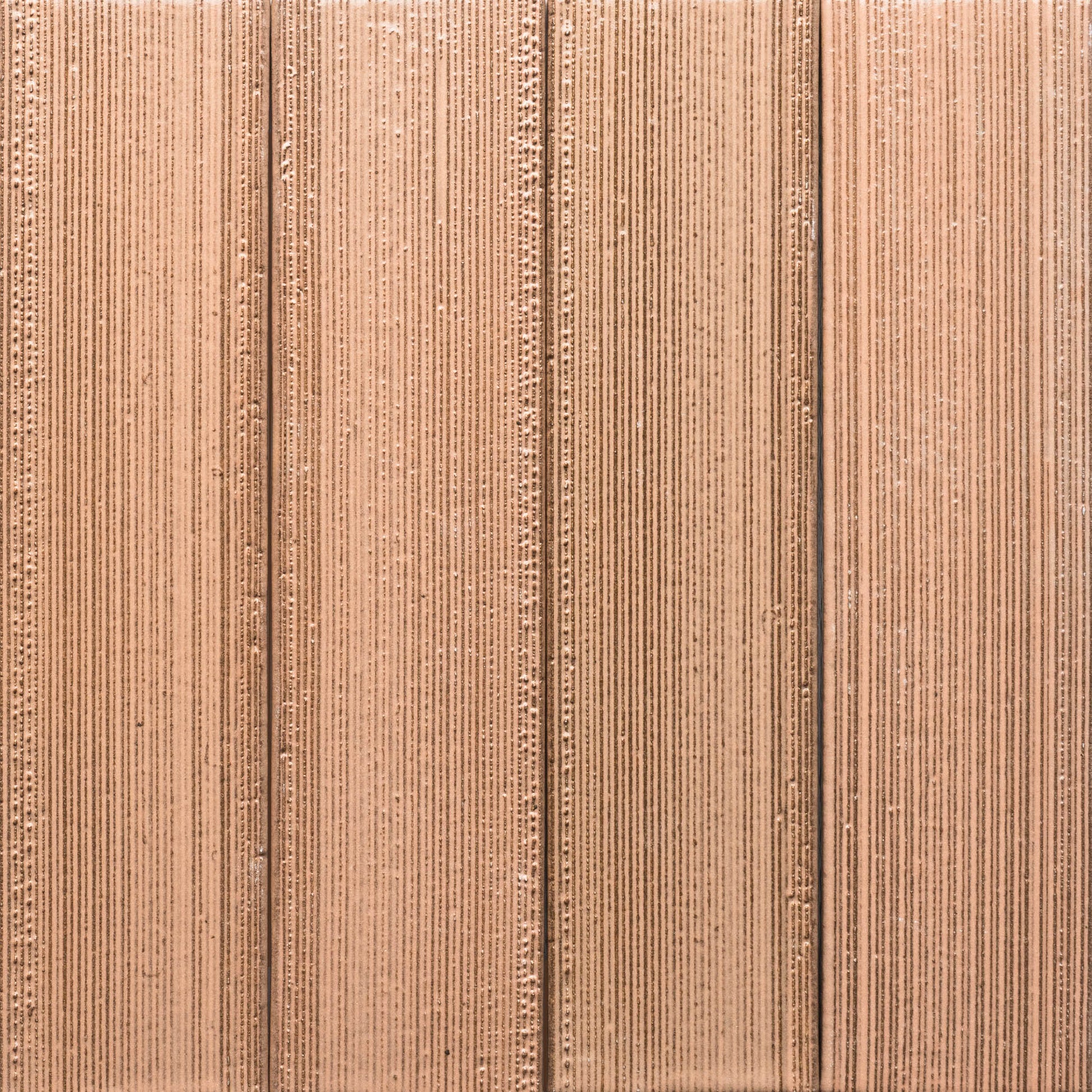 Close-up of Sakura + Etched by Zia Tile reveals its textured, light brown corrugated surface with vertical ridges and grooves in a repeating linear pattern.