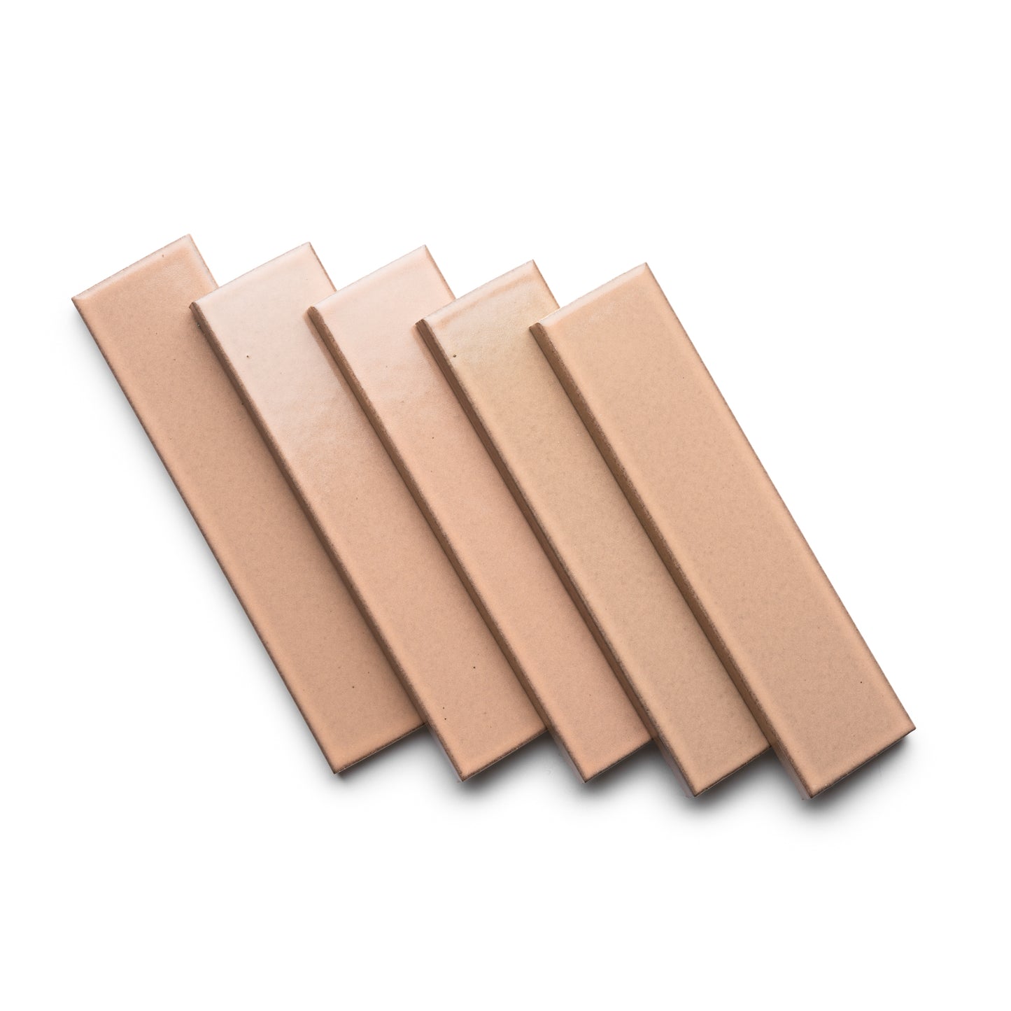 Five Sakura + Flat tiles by Zia Tile in rectangular, light brown ceramic are arranged in a neat, overlapping diagonal pattern on a white background.