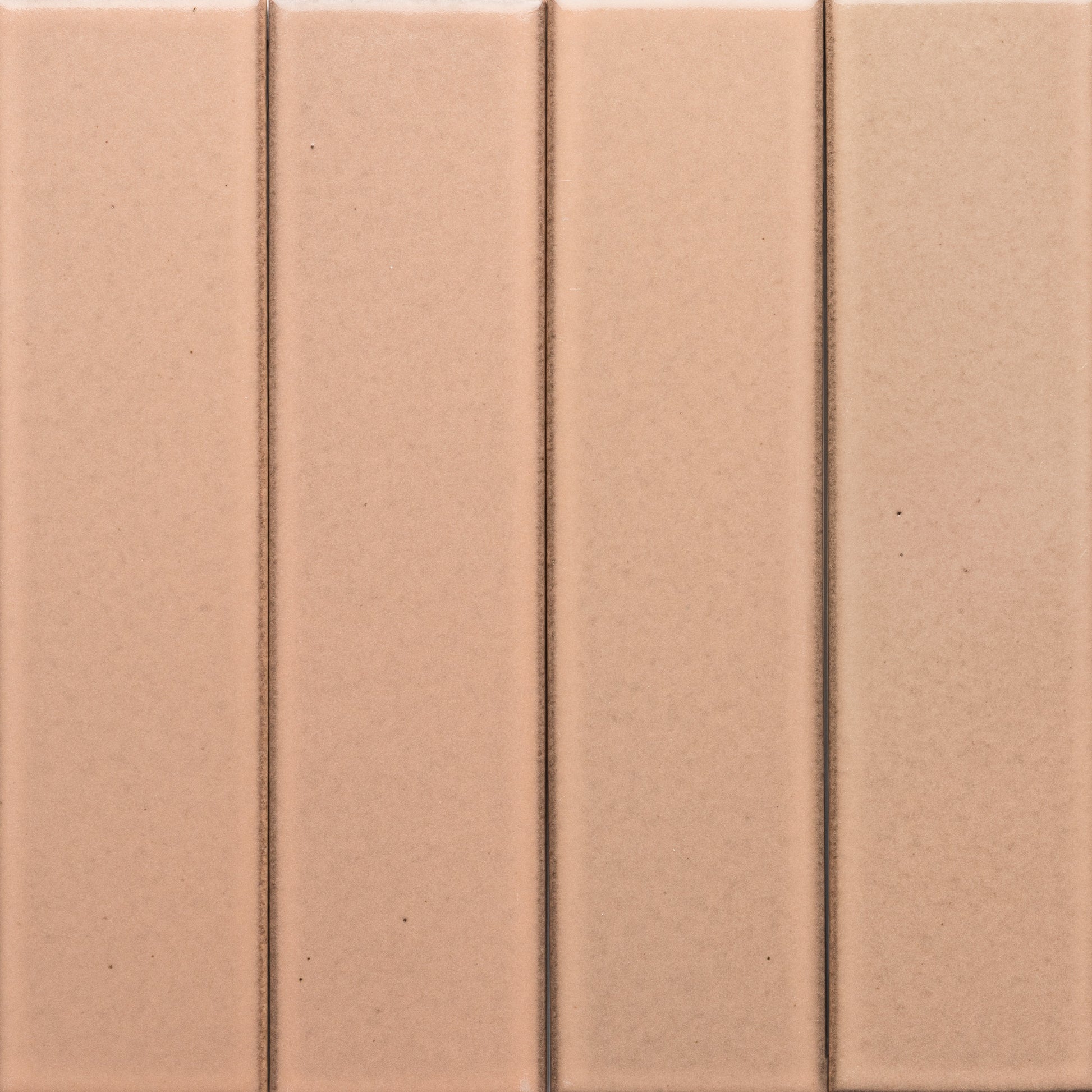 Close-up of four vertical, rectangular Sakura + Flat tiles in light brown by Zia Tile, featuring subtle grout lines that create a clean, simple geometric pattern.