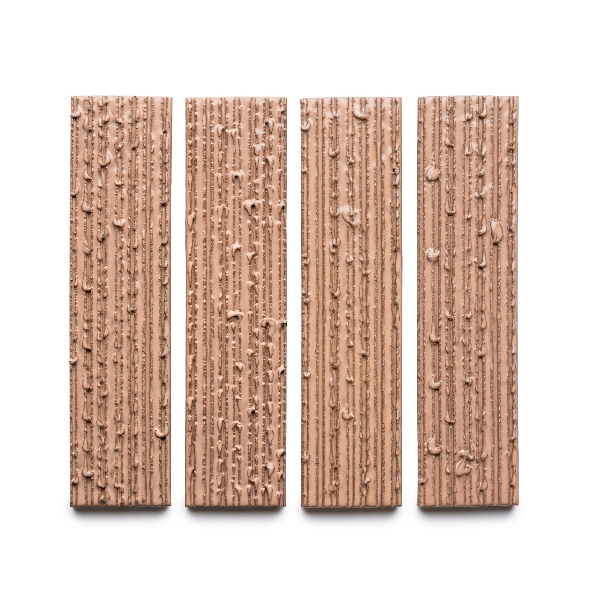 Four Sakura + Furrowed chocolate bars by Zia Tile, each rectangular with a textured surface of vertical ridges and small bumps, are arranged side by side on a white background.