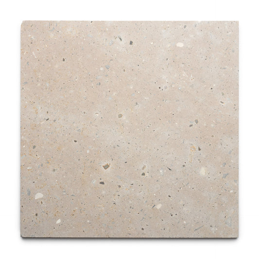 The Sierra 24x24 tile by Zia Tile is a square beige Cantera tile with a smooth surface and subtle gray, white, and tan specks. Made from natural volcanic stone, it reflects the authentic charm of Mexican Cantera craftsmanship. Set on a white background.