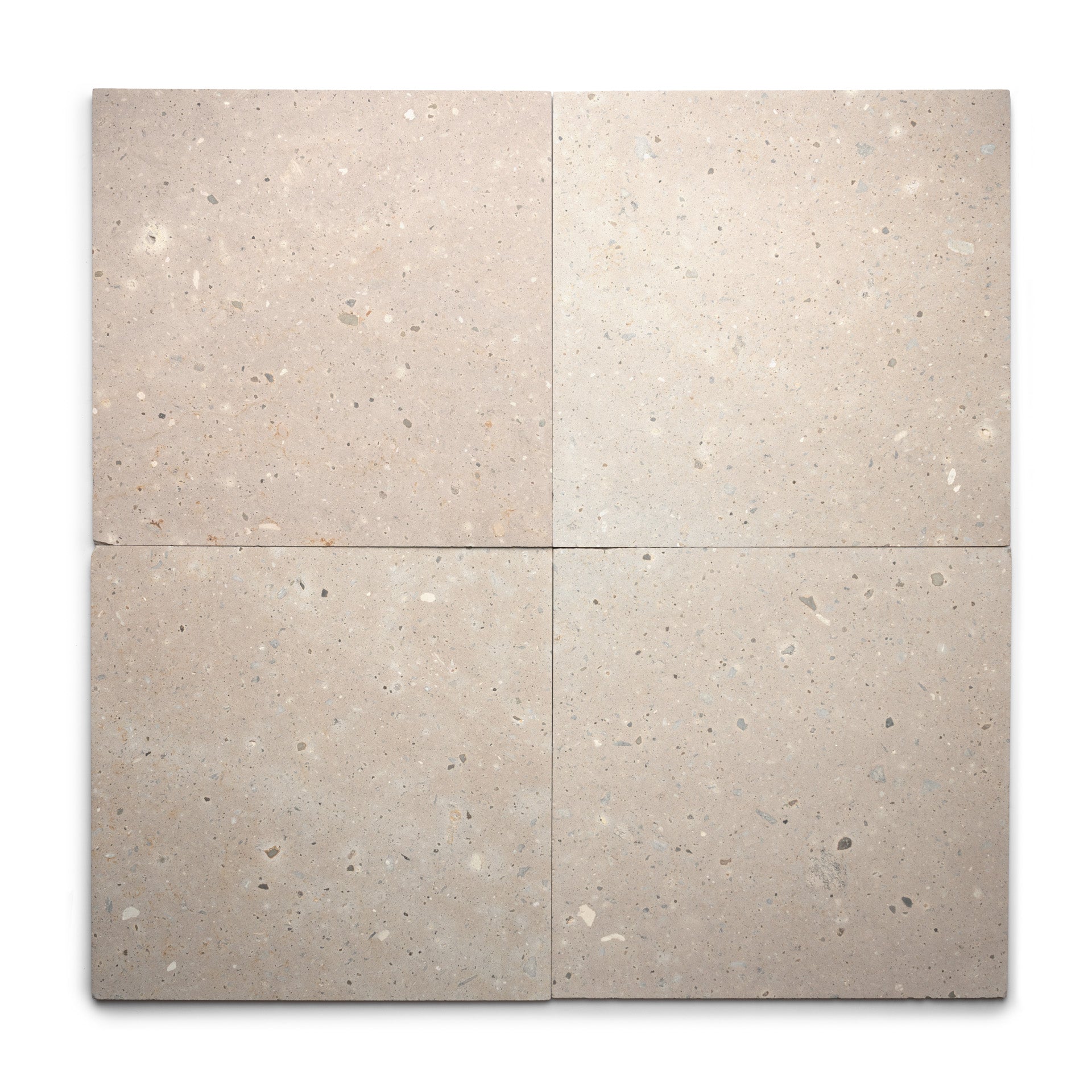 Four square Sierra 24x24 tiles by Zia Tile, in light beige Cantera stone with subtle speckling, are arranged in a grid on white. The natural volcanic stone has a slightly rough texture for an authentic appearance.