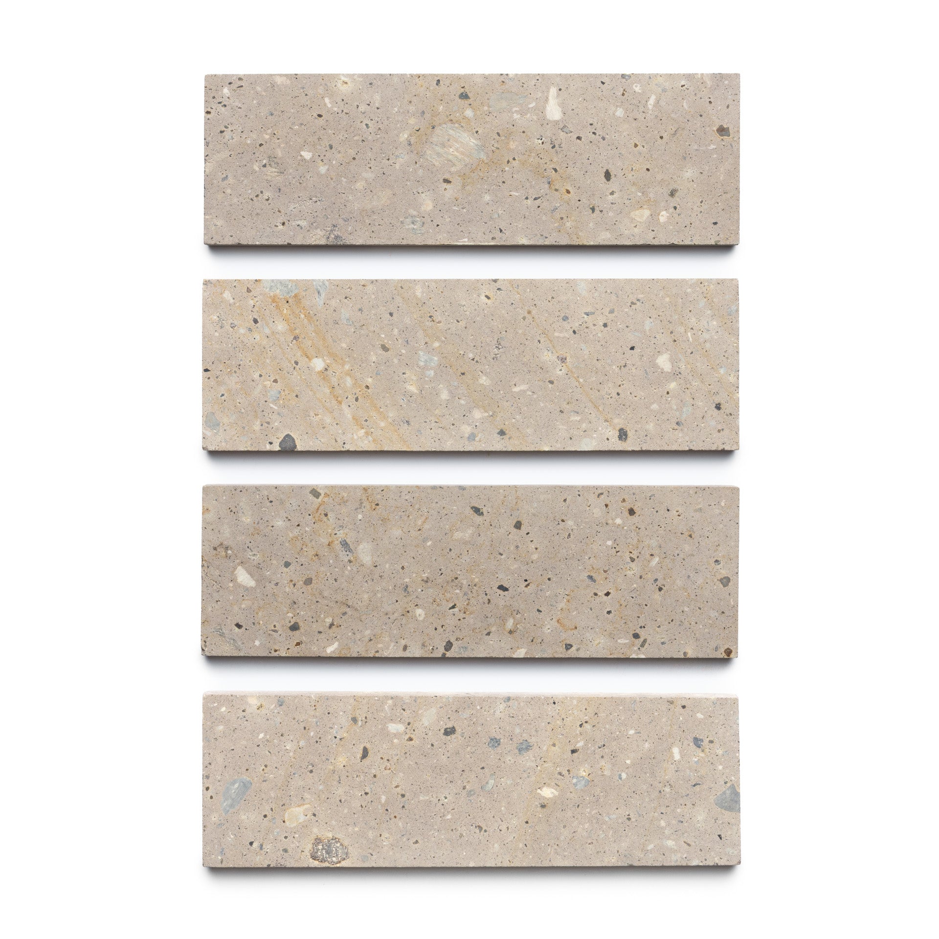 Four rectangular Sierra 4x12 tiles by Zia Tile are arranged vertically on a white background, highlighting the beige hues, small specks, and natural volcanic stone textures.