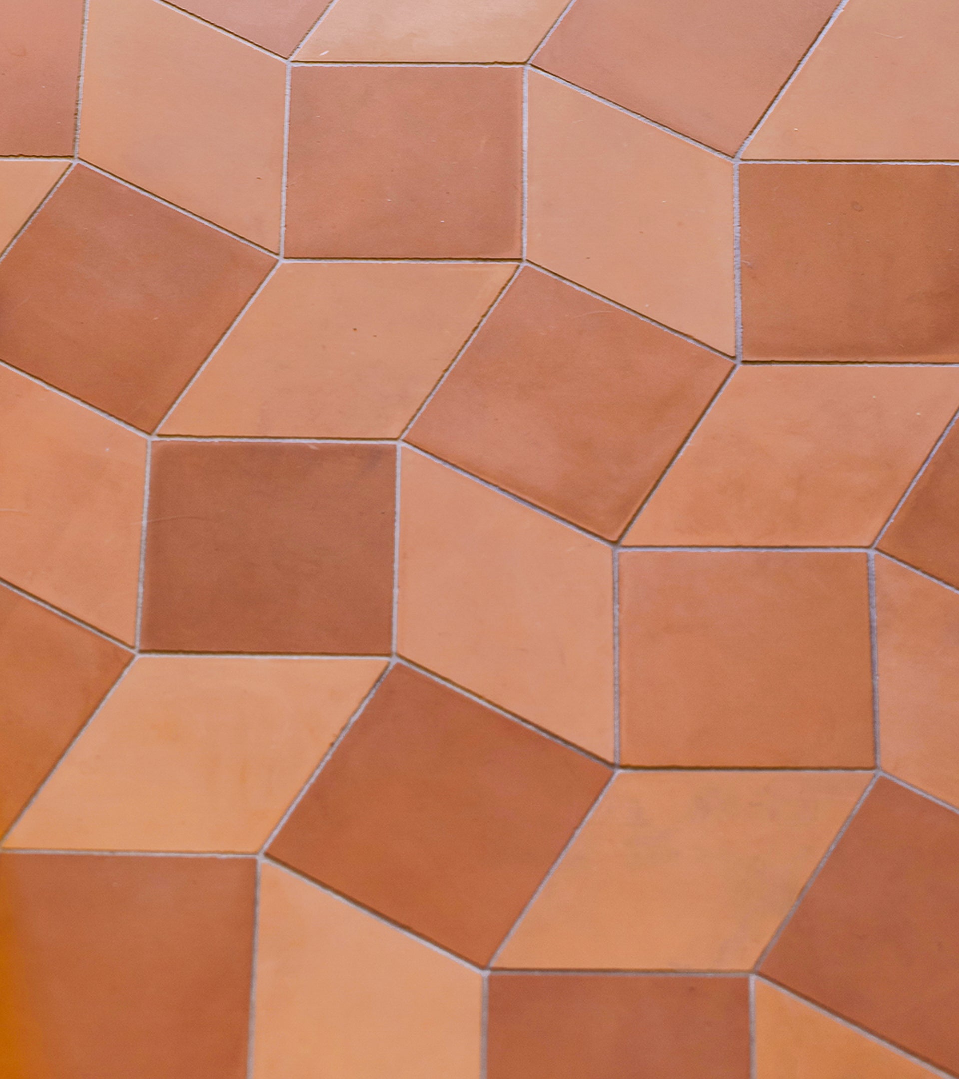Madrid Terra Cotta + Rust by Zia Tile features earthy, reddish-brown and light tan tones in a repeating geometric pattern that creates a three-dimensional cube illusion for a striking handmade tile look.