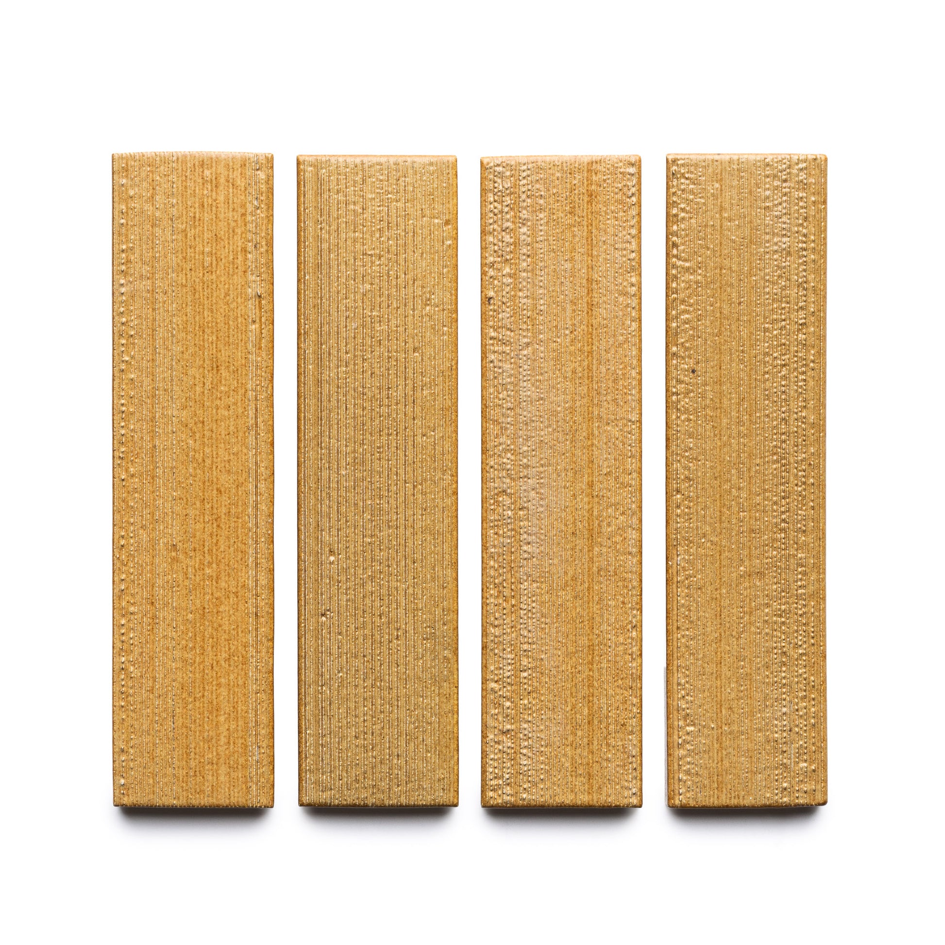 Four Toast + Etched rectangular, textured, light brown wooden blocks by Zia Tile are arranged vertically in a row on a white background.