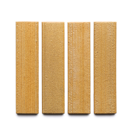 Four Toast + Etched rectangular, textured, light brown wooden blocks by Zia Tile are arranged vertically in a row on a white background.