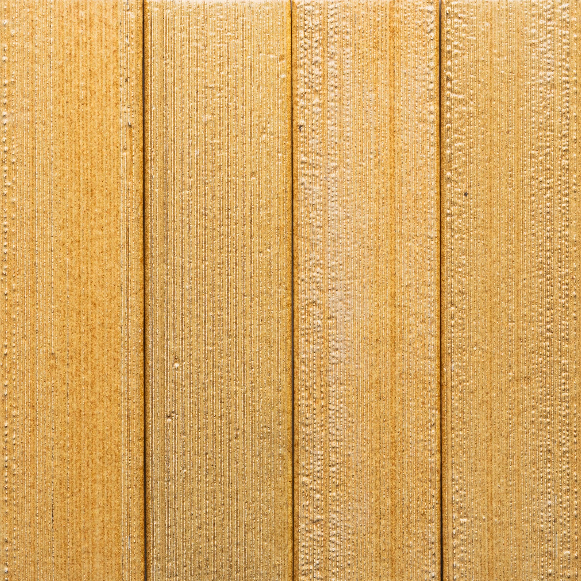 Close-up of Toast + Etched by Zia Tile, featuring four vertical light brown wooden planks with textured grain patterns and subtle lines.