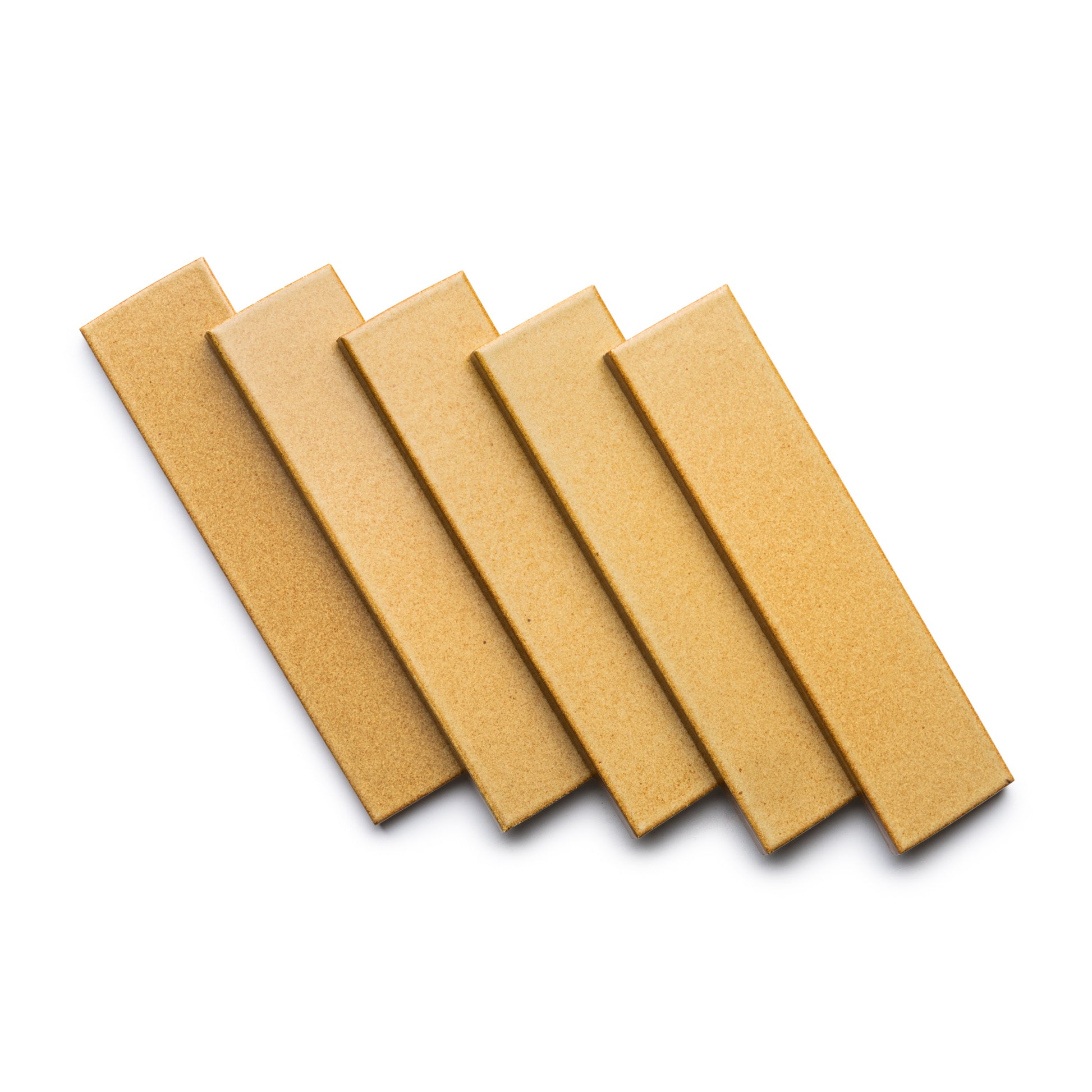 Five Toast + Flat rectangular tan ceramic tiles by Zia Tile are neatly overlapped in a row on a white background.