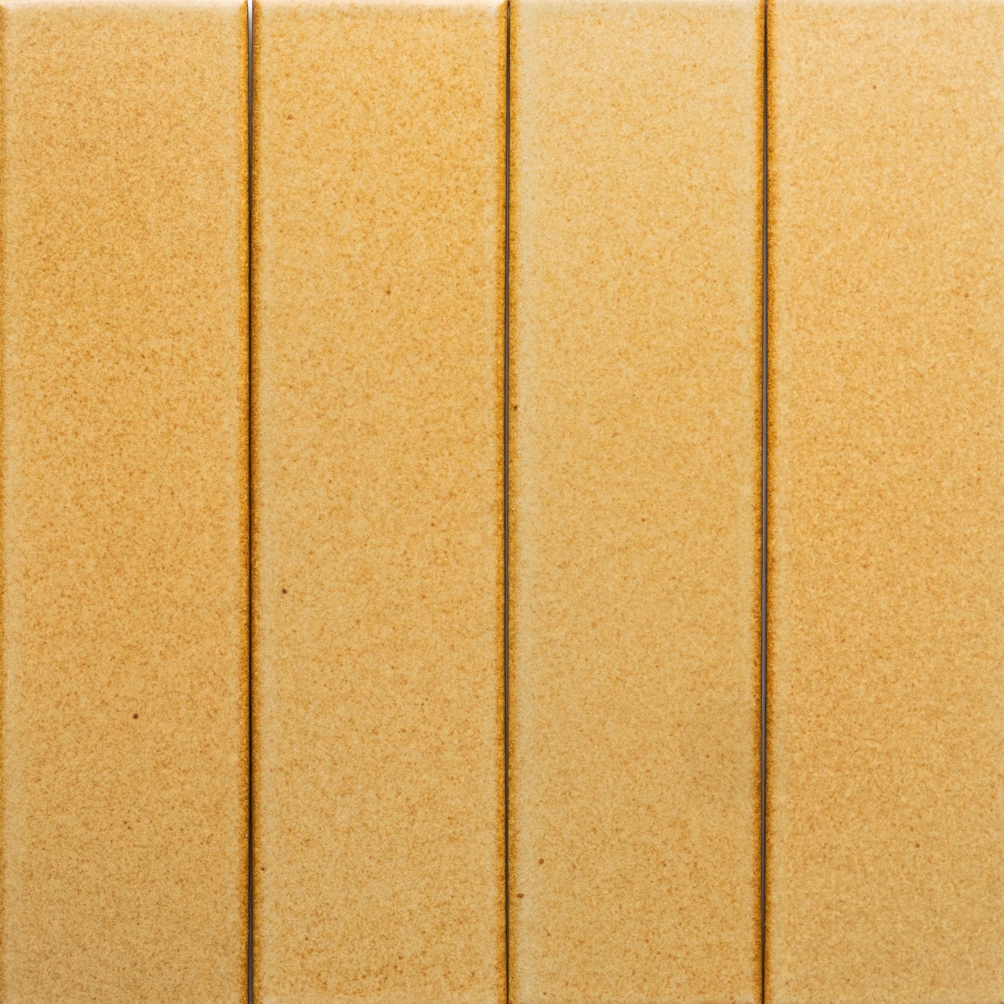 Four Toast + Flat tiles by Zia Tile are arranged vertically side by side, creating a seamless beige surface with narrow grout lines and a smooth, slightly speckled texture.