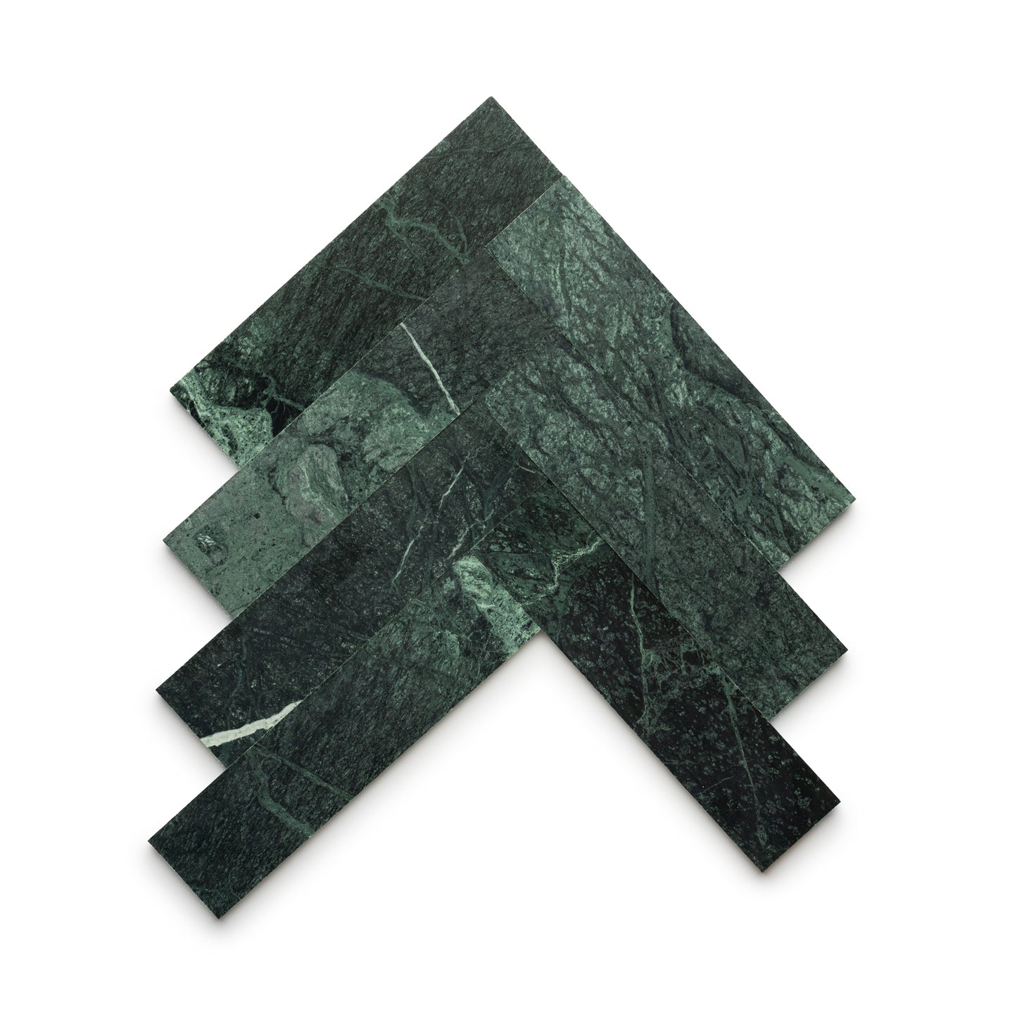 Four rectangular Verde Alpi 3x12 tiles by Zia Tile, in dark green marble with white veining, are arranged in a chevron pattern on a white background, highlighting the artistry of handmade tile.