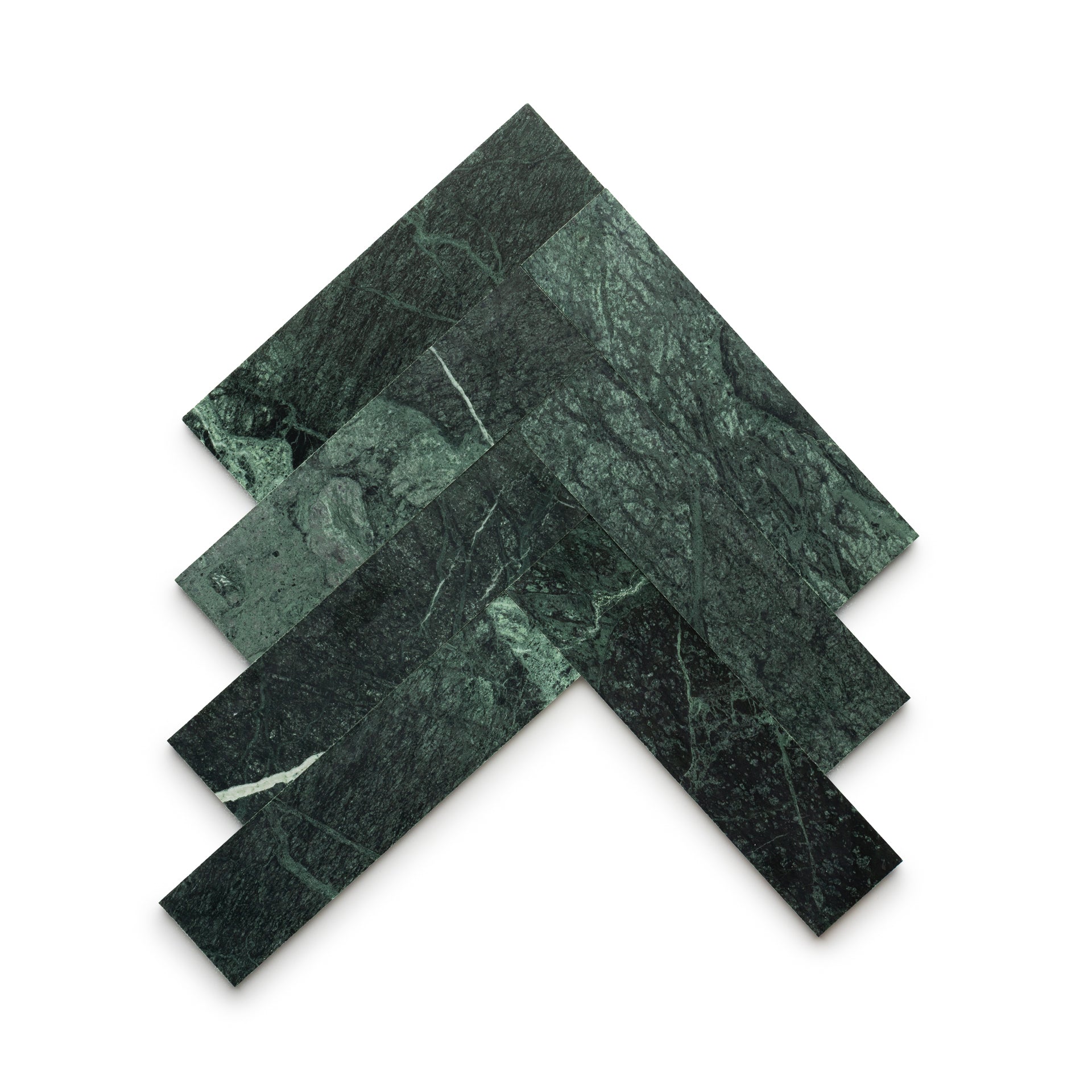 Four rectangular Verde Alpi 3x12 tiles by Zia Tile, in dark green marble with white veining, are arranged in a chevron pattern on a white background, highlighting the artistry of handmade tile.
