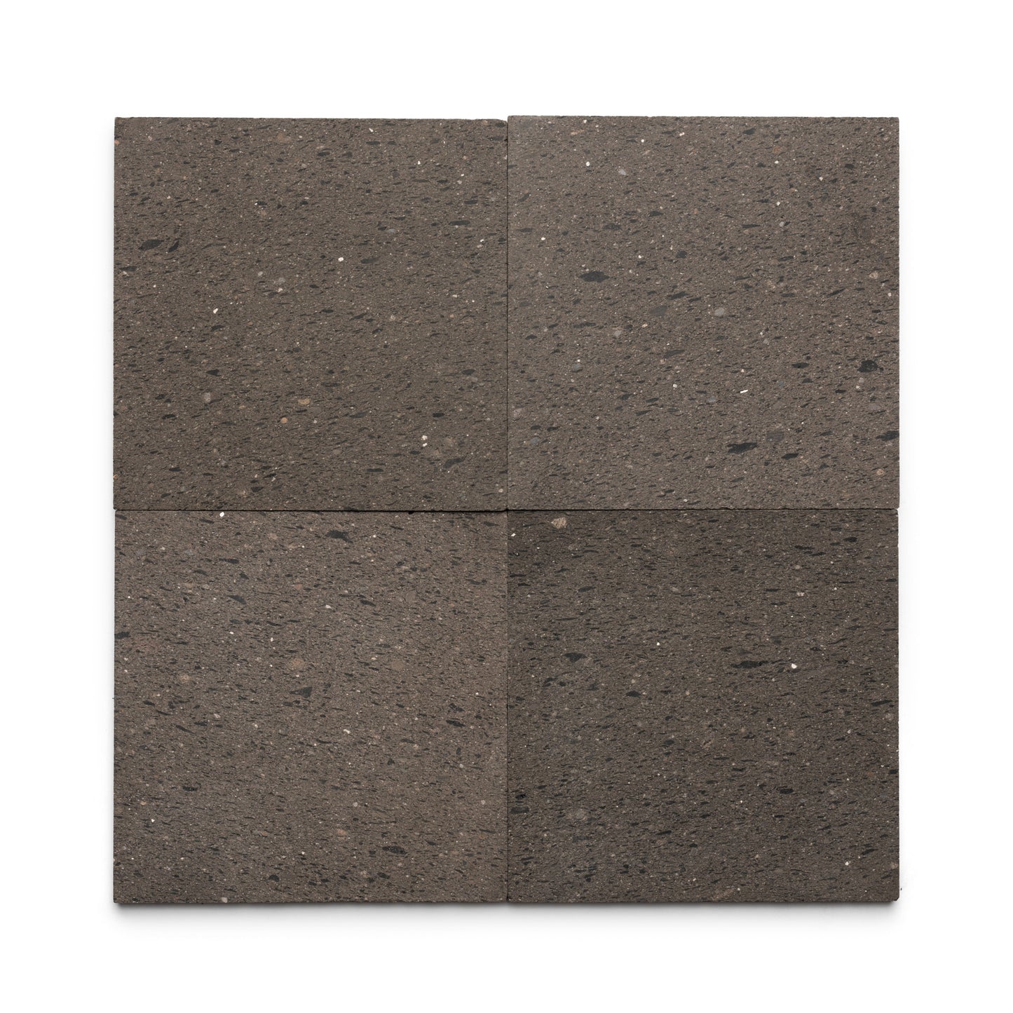 Four Volcan 12x12 tiles by Zia Tile are arranged in a 2x2 grid on a white background. These dark gray Mexican Cantera tiles have a speckled, textured volcanic stone surface with natural color and pattern variations.