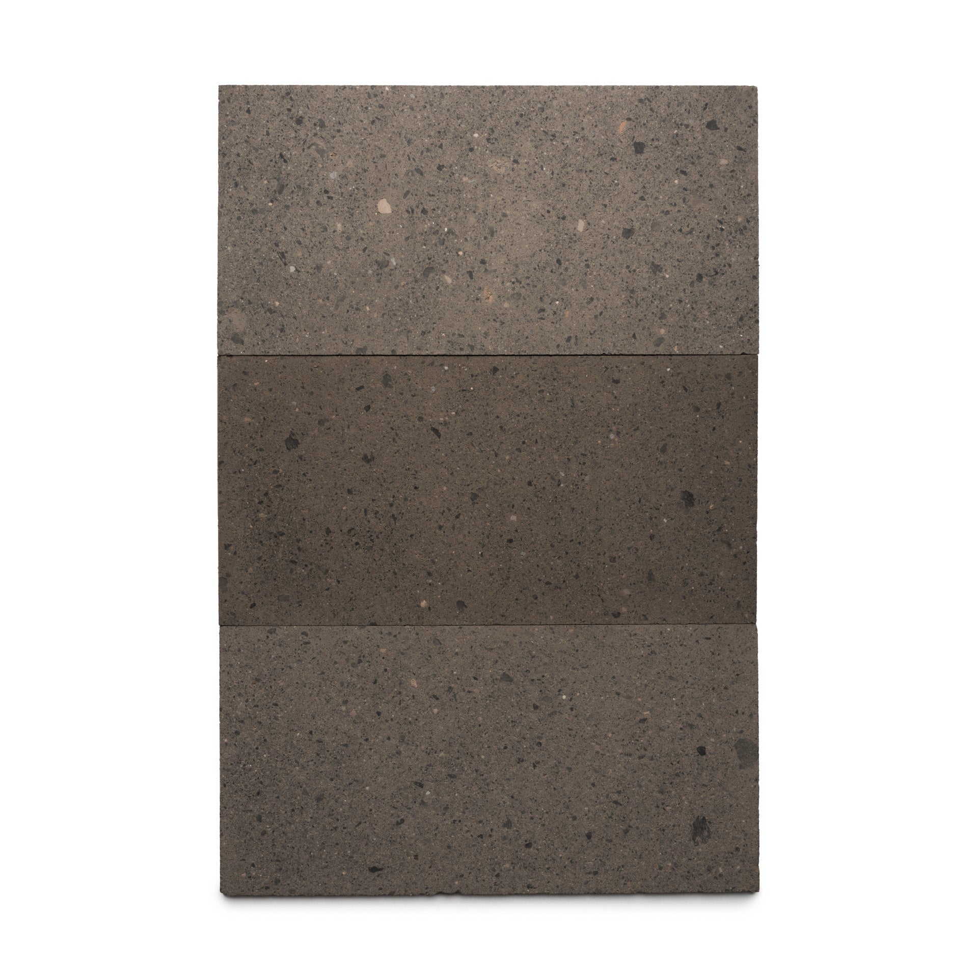 The Volcan 12x24 by Zia Tile is a rectangular, vertical slab of Mexican Cantera featuring a speckled gray texture. It's horizontally divided into three sections, with the darker middle section highlighting its natural volcanic stone look.