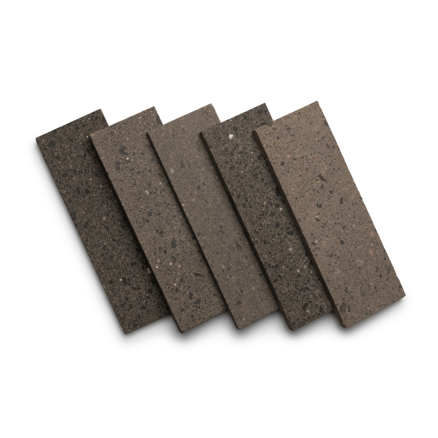 Five Zia Tile Volcan 4x12 rectangular tiles in earthy brown and gray tones are displayed fanned out on a white background. Each tile shows a speckled, textured surface characteristic of the collection.