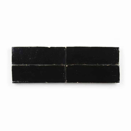 Four Carbon Black 2x6 tiles are arranged in two rows with slight gaps, showcasing the artisanal charm of Moroccan tilework against a crisp white background.